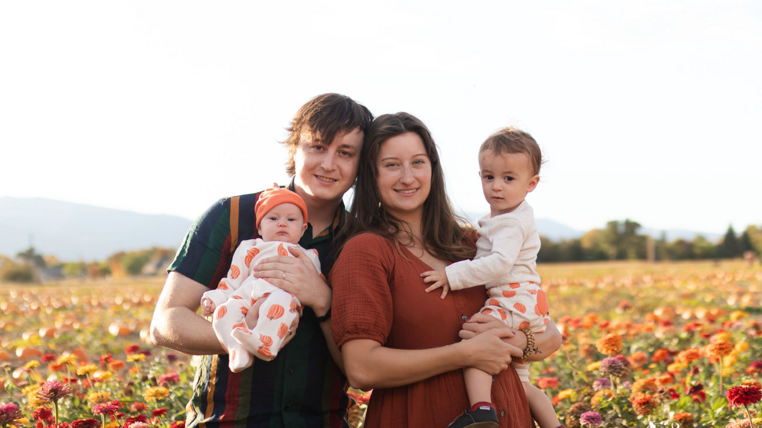 Two adults holding two children in a field of flowers